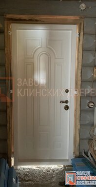входная дверь с отделкой филенчатой мдф панелью в срубе дома из бревна - фото внутри